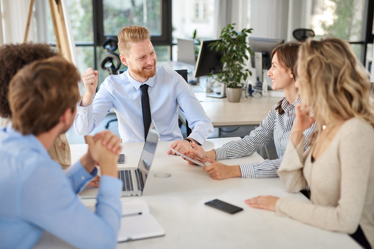 Kleine Gruppe von Führungskräften im Gespräch am Tisch